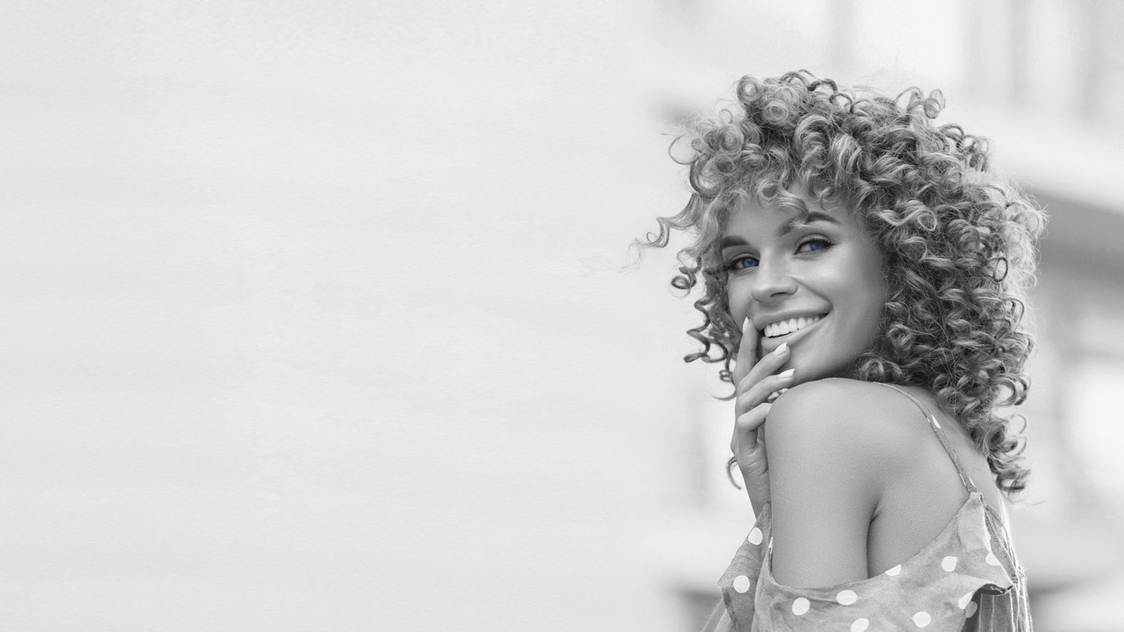 Hero Image of a beautiful woman with curly hair smiling | Preferred Aesthetics & Wellness